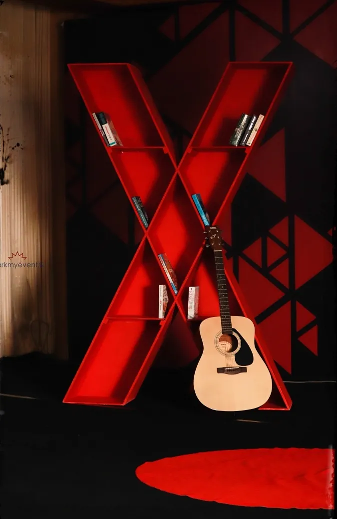 A red X set piece with an acoustic guitar resting in it