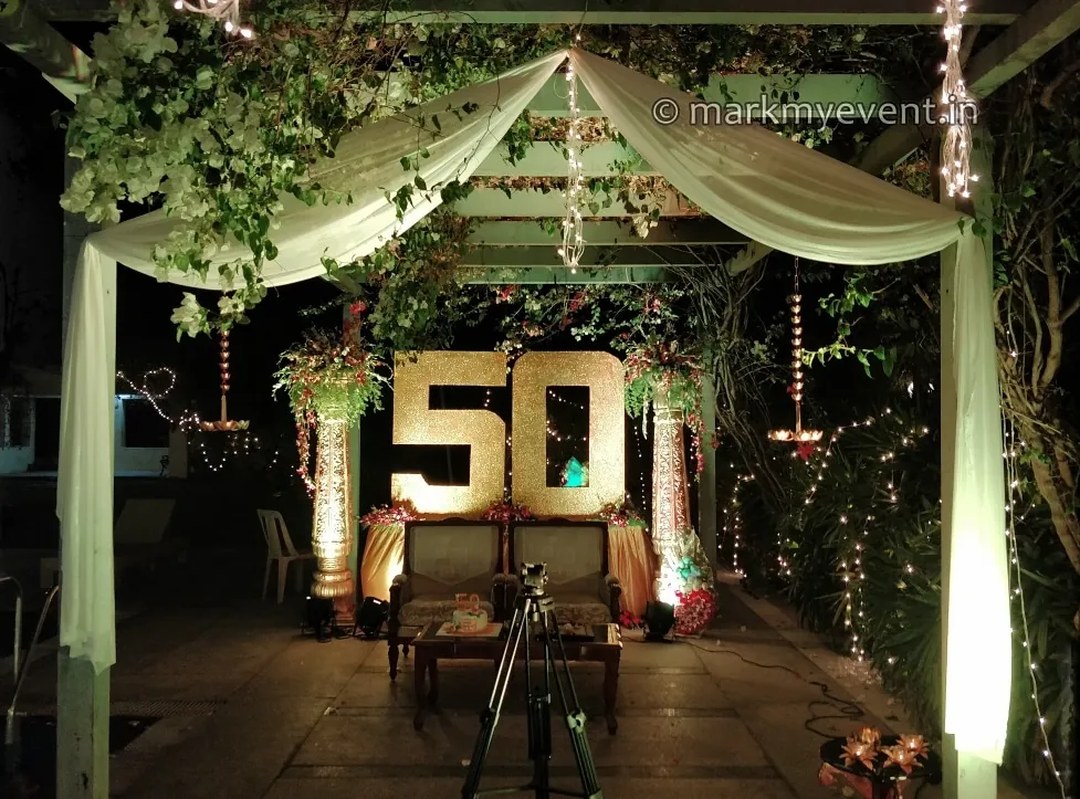 A gazebo draped in white and lit with fairy lights at night
