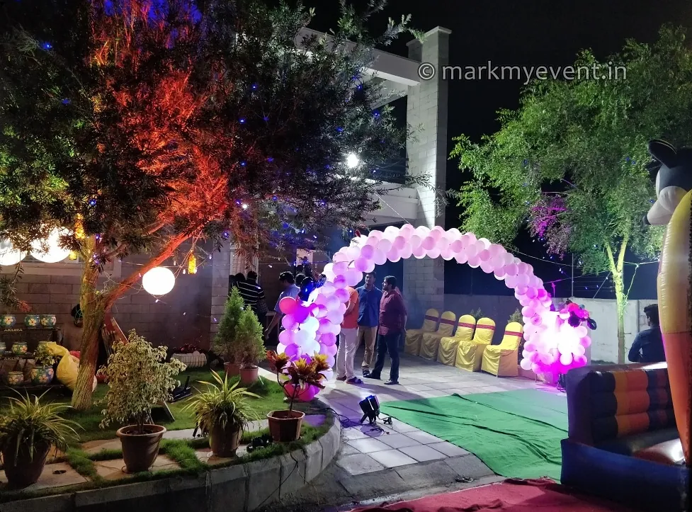 A garden evening with a balloon arch and coloured lighting