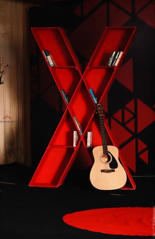 A red X installation with a guitar resting inside it